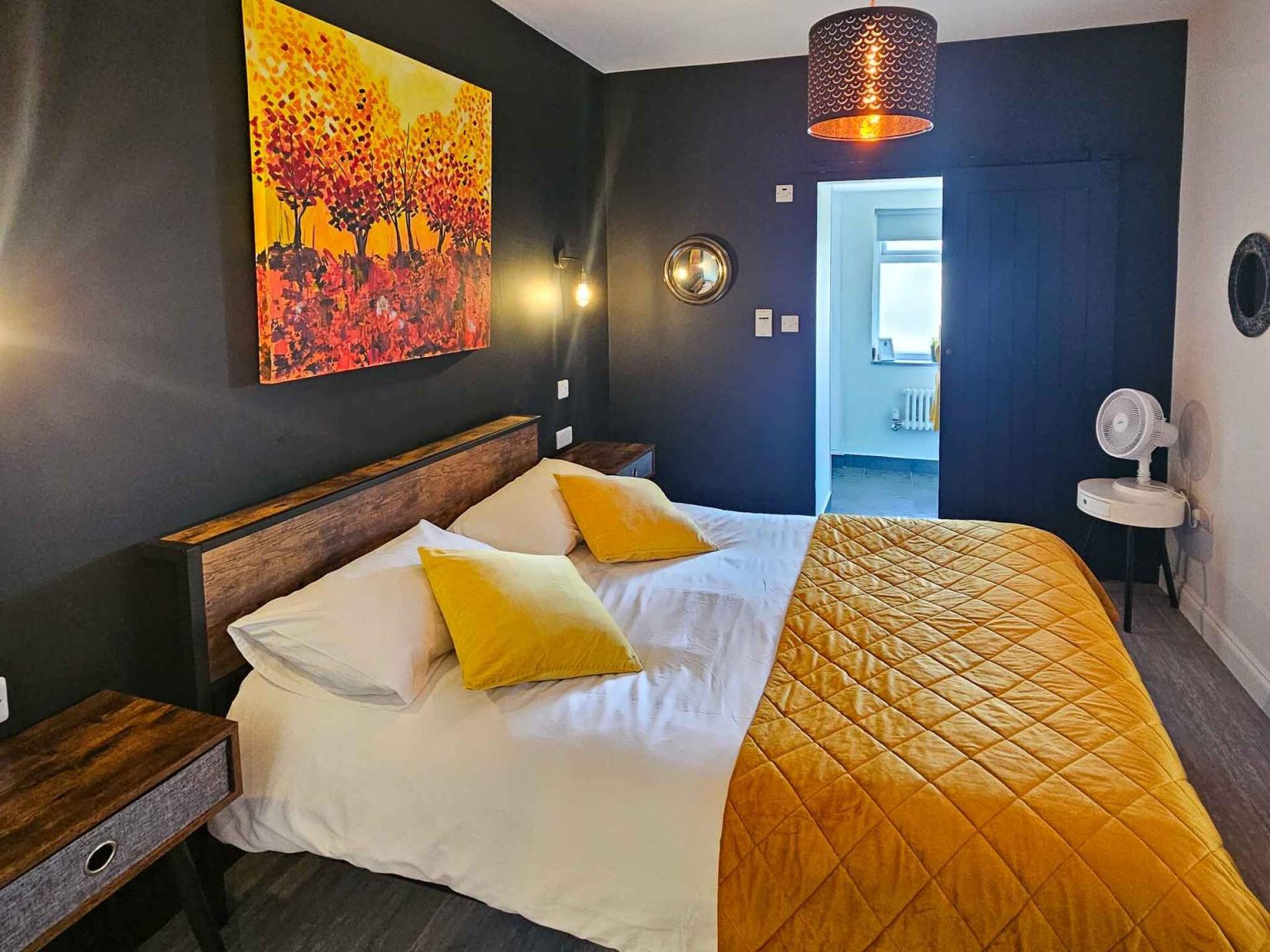 Orchid Suite bedroom with navy walls and original artwork